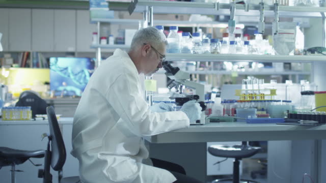 El-científico-masculino-está-trabajando-en-un-microscopio-en-un-laboratorio.