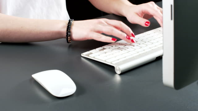Mujer-utilizando-ratón-y-escribiendo-en-un-teclado
