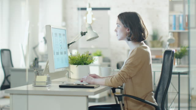 Creative-Brunette-Working-on-Design-at-Her-Desktop-Computer.-Sitting-in-Her-developer-Office.