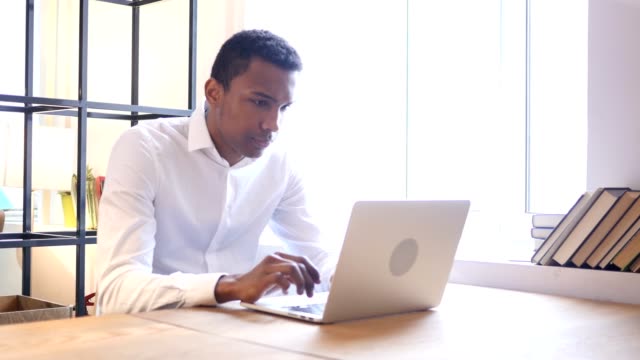Ansioso-preocupado-hombre-negro-trabajando-en-ordenador-portátil