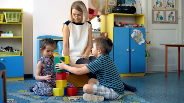 Zwei-Kleinkinder-Kinder-bauen-Turm-der-bunten-Kunststoffblöcke