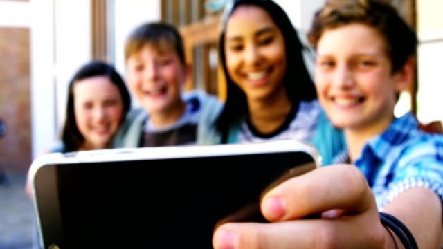 Escolares-sonrientes-tomando-selfie-con-teléfono-móvil