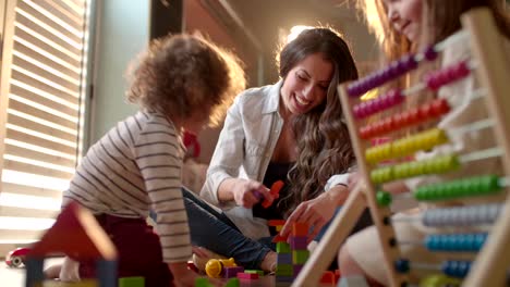 Cute-children-and-their-mother-excitedly-playing-with-toy-blocks
