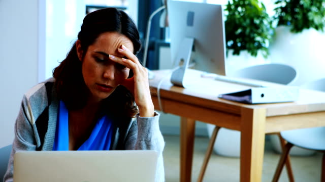 Mujer-ejecutiva-trabajando-en-ordenador-portátil-en-la-oficina
