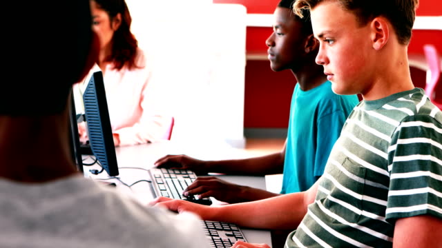 Estudiantes-trabajando-en-la-computadora-en-montaje-tipo-aula