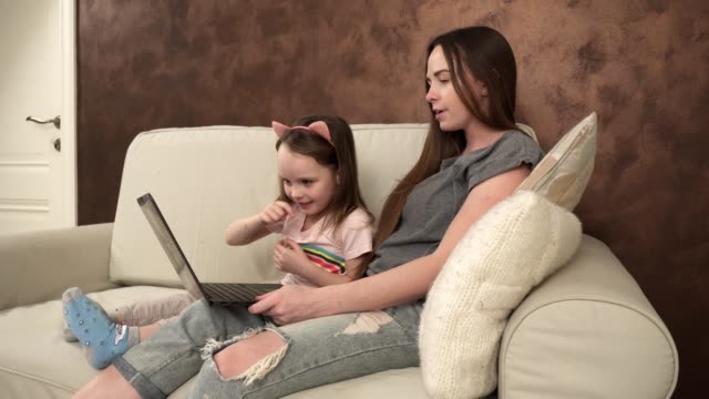 Kleine-Mädchen-zeigt,-etwas-zu-ihrer-Mutter-auf-dem-laptop