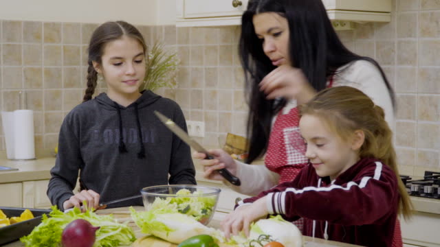 Kleine-Mädchen-helfen-Mutter-Salat-zum-Abendessen-kochen