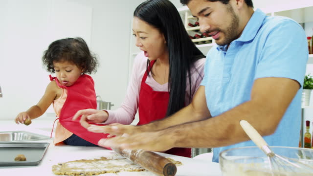 Little-Asian-girl-having-fun-baking-with-parents