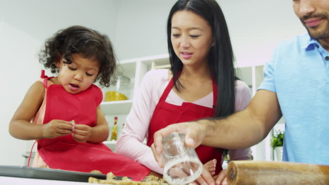 Ethnische-Pre-School-Mädchen-Eltern-Backen-Küche-zu-Hause