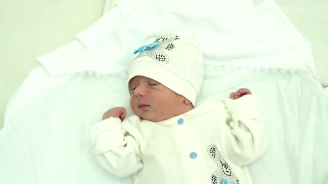Primer-plano-de-un-bebé-recién-nacido-en-el-sombrero-blanco-se-encuentra-en-cama.