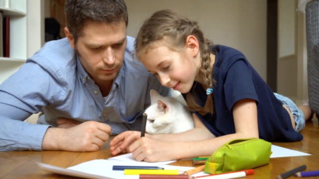 Familia-con-gato-dibujando-en-el-piso.