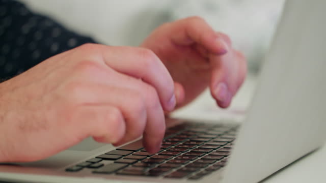 Hände-des-Mannes-auf-einem-Laptop-eingeben