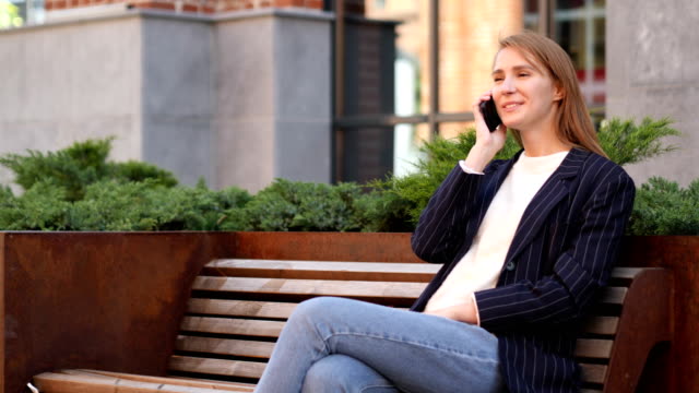 Young--Woman-Negotiating-on-Phone,-Discussing-with-Friend