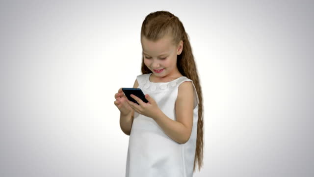 Kleines-Mädchen-mit-Smartphone-auf-weißem-Hintergrund