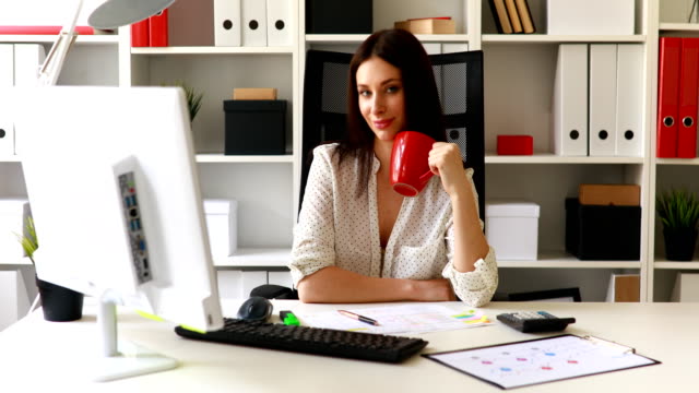 businesswoman-with-cup-working-in-office