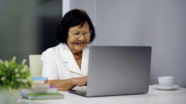 glücklich-senior-Frau-arbeitet-auf-Laptop-computer