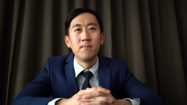 Hombre-de-negocios-asiático-joven-habla-sobre-la-llamada-de-video-conferencia-con-mirada-seria