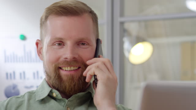 Happy-Businessman-Speaking-on-Phone-at-Work