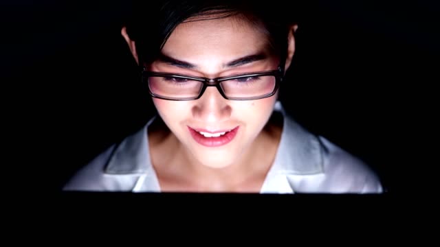 Close-up-of-beautiful-asian-woman-talking-to-customer-using-video-call-in-computer,-wearing-glasses,-happy-mood.