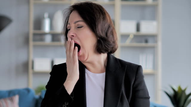 Tired-Old-Businesswoman-Yawning