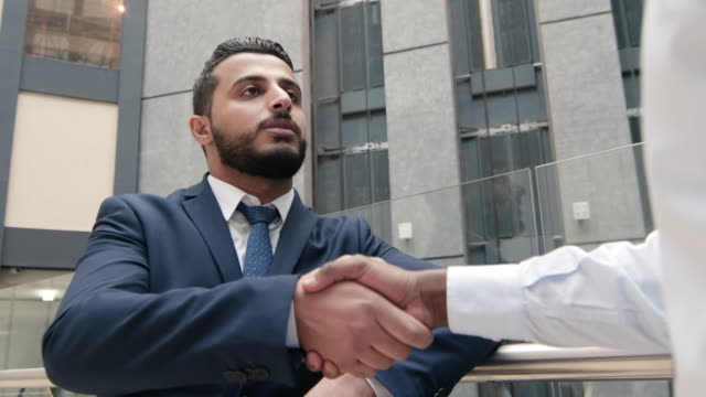 Arabische-Geschäftsmann-Händeschütteln-mit-Kollege-indoor