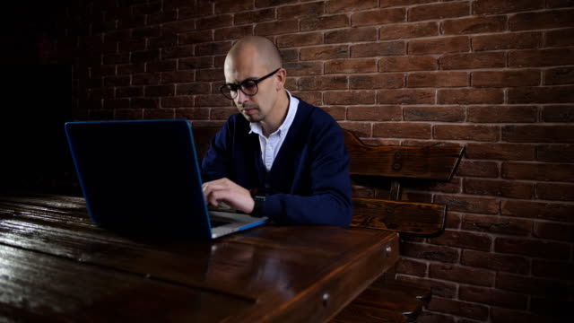 Hombre-de-negocios-con-gafas-está-escribiendo-texto-en-el-teclado-del-ordenador-portátil.-El-trabajo-de-freelance.