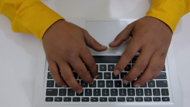 Draufsicht-der-indischen-männlichen-Händen-tippen-auf-einer-Tastatur-von-einer-Computer-Seitenansicht,-wie-er-seine-Hände-zurückzieht