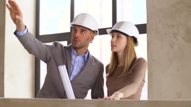 architects-with-blueprint-and-helmets-at-office