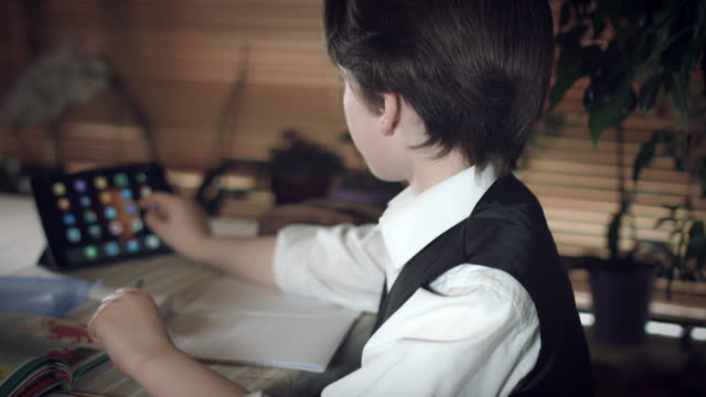 4K-Hi-Tech-Shot-of-a-Child-Doing-Homework-and-Searching-Tablet
