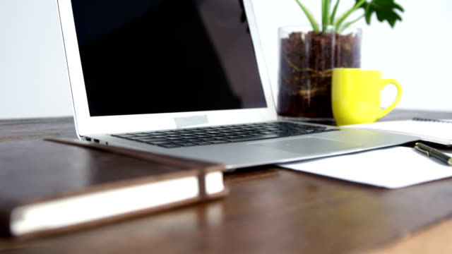 Laptop,-Notebook-und-Tasse-Kaffee-auf-Holztisch-angeordnet