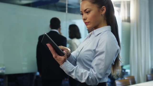 Geschäftsfrau-nutzt-Tablet-in-Crowded-Office