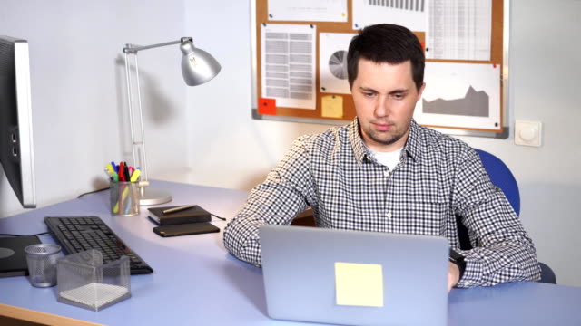 Empleado-de-oficina-en-el-trabajo.-Hombre-sentado-en-el-escritorio-y-el-uso-del-ordenador-portátil.
