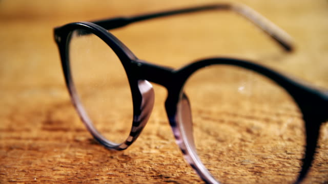 Spectacles-on-wooden-table-4k