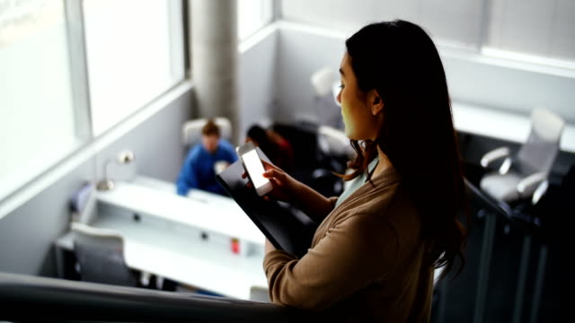 Female-executive-using-mobile-phone