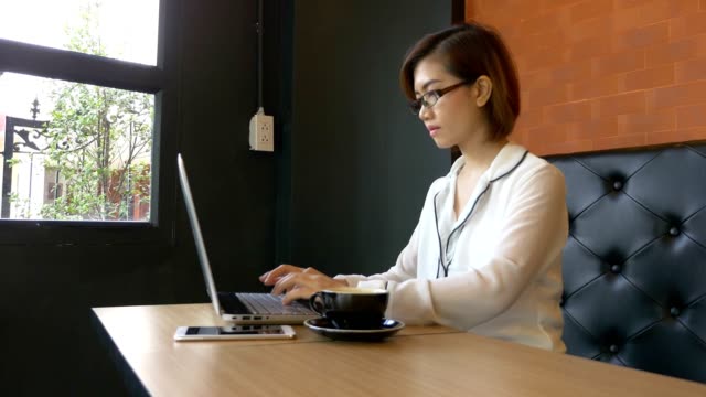 Asiatische-Geschäftsfrau-Arbeit-durch-Eingabe-auf-Laptop-Tastatur