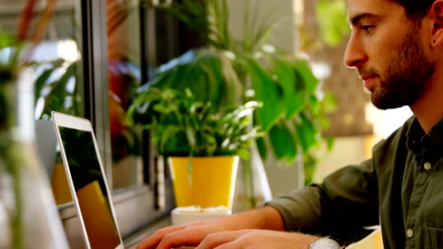Close-up-of-handsome-man-using-laptop-at-table-4k