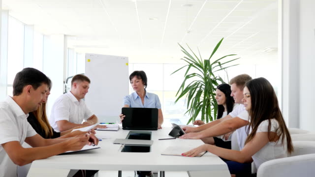 Chefin-vor-Laptop-auf-Treffen-mit-Partnern-diskutieren-Ideen-Geschäftsentwicklung-in-modernen-Sitzungssaal