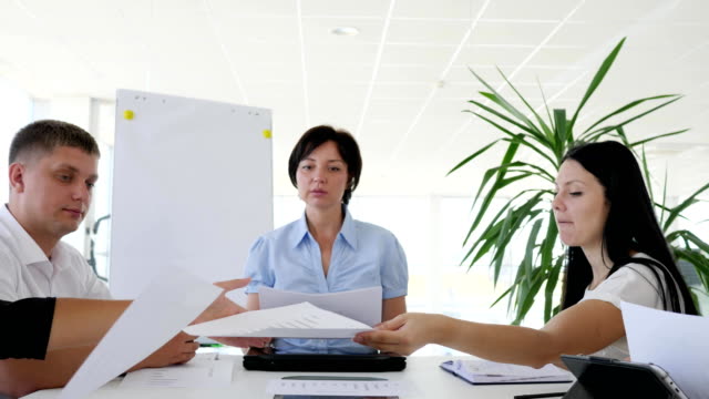 Business-Meeting-Mitarbeiter-an-Rezeption-mit-Dokumenten-in-der-Hand-im-Sitzungssaal