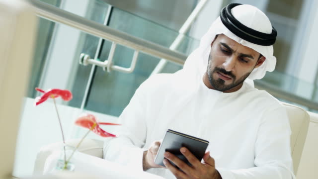 Hombre-de-negocios-árabe-vestido-nacional-utilizando-tecnología-de-tableta