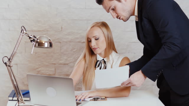 man-and-woman-are-working-on-a-computer-with-documents