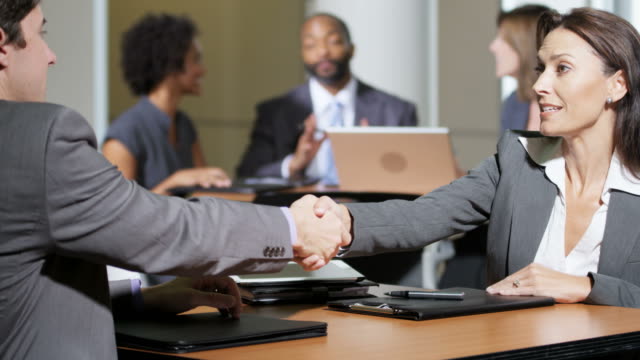Caucasian-female-financial-advisor-opening-meeting-with-handshake