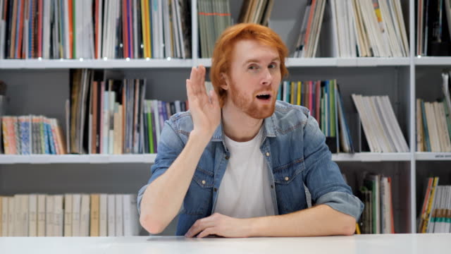 Redhead-Man-Listening-Secret-Carefully-in-Office,-Library