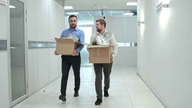 Men-Going-with-Belongings-through-Office-Hallway
