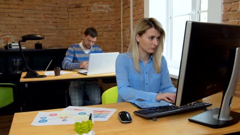 Closeup.-Portrait-of-a-beautiful-young-woman-and-man-working-on-computers-in-the-office.