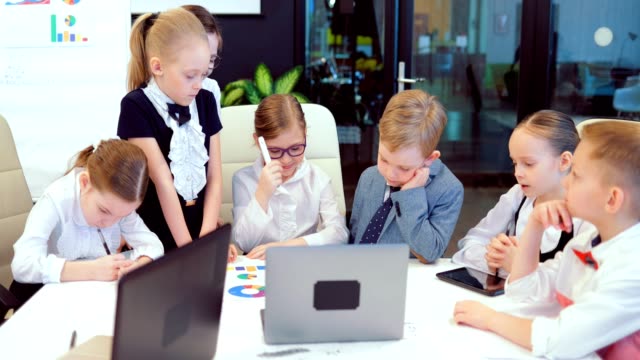 Young-and-bright-modern-small-creative-children-business.-Modern-office.-Children-discuss-business-ideas