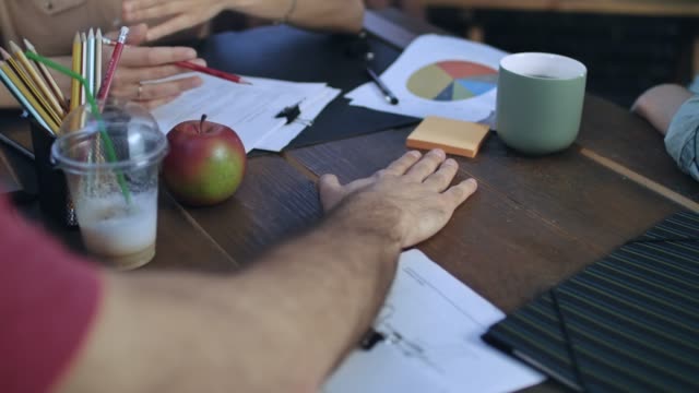 Hombres-de-negocios-poner-manos-sobre-mesa-para-conectar-con-el-equipo-en-la-reunión-de-inicio