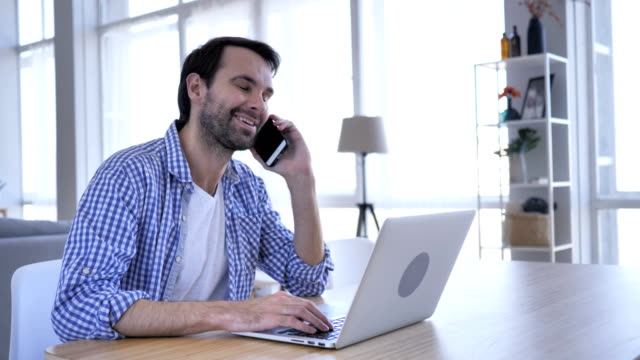 Negotiation,-Casual-Beard-Man-Talking-on-Phone-At-Work-to-Discuss-Plan-,4k-,-high-quality
