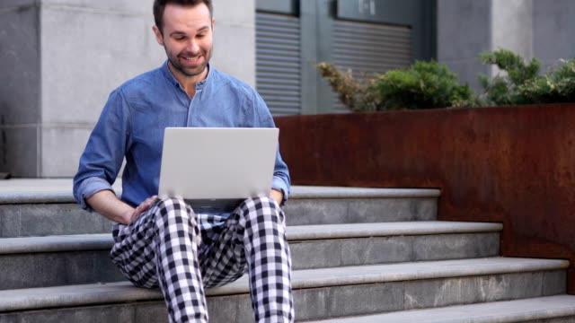 Online-Video-Chat-en-portátil-sentado-en-las-escaleras-fuera-oficina