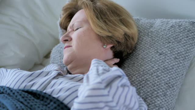 Mujer-Senior-viejo-cansada-con-dolor-de-cuello-durmiendo-en-la-cama