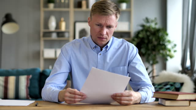 Businessman-Upset-after-Reading-Documents-at-Work